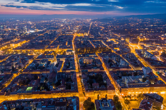 Aerial view of the radiant cityscape unfolds with golden lights tracing streets towards Zagreb Cathedral under the fading twilight, Zagreb, Croatia.