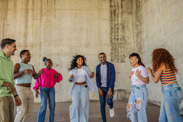 Diverse group of young friends dancing and celebrating