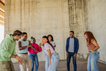 Diverse gen z friends laughing and dancing outdoors