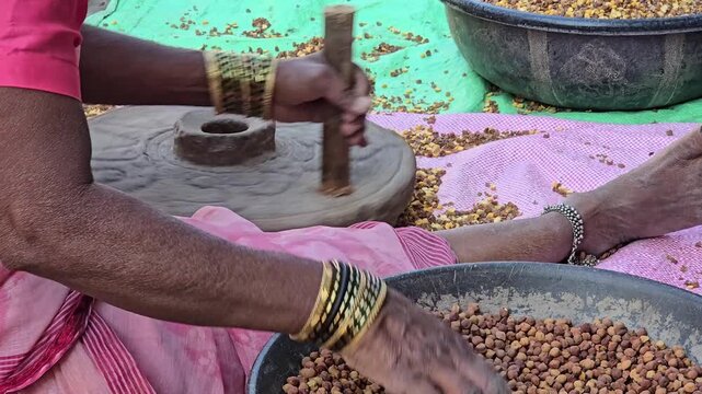 A woman sat operating the stone chakki. The mill groaned with each turn, grinding dried chickpeas into pulses and flour. This rhythmic chore is a testament to tradition and heritage.