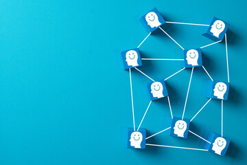 Positive thinking and mental health concept. Network of blue blocks with smiling face icons symbolizing happiness, customer satisfaction, and social connection on a blue background with copy space.