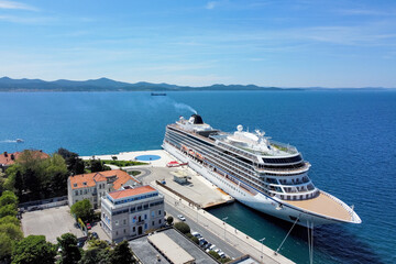 Zadar, Croatia - 18 November 2025: Aerial view of a majestic cruise ship docked at the harbor, juxtaposed against the azure Adriatic Sea and historic buildings.