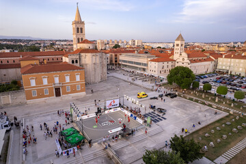 Zadar, Croatia - 18 November 2025: Aerial view of the vibrant Petar Zoranic Square bathed in warm light, showcasing a basketball event amidst historic architecture and bustling activity.