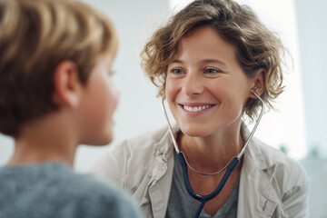 Female doctor speaking gently with young boy during medical checkup