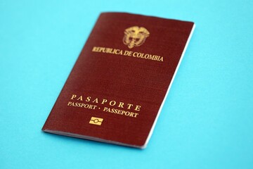 Colombia Republic red passport on light blue table background close up. Concept of travel and tourism