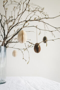 Easter paper eggs hanging on branches. Easter decor.