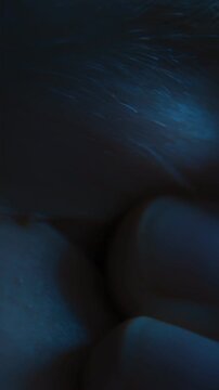 Close-up of a tired eye of a man wearing eyeglasses who takes off his glasses and rubs his eyes from fatigue after long computer screen time or doomscrolling. Eye strain, overwork, and vision problems