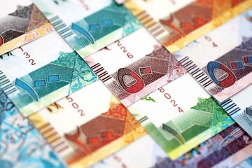 Qatari riyal money bills banknotes lies in big pile on table close up. Concept of finances and business in Qatar