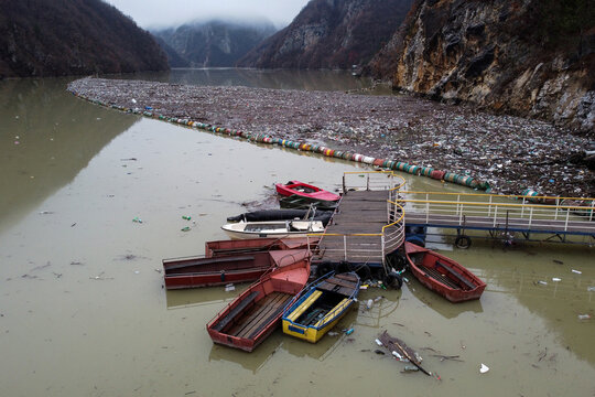 Aerial view of a river choked with plastic waste, a stark contrast to the natural beauty of the surrounding mountains, Visegrad, Republika Srpska, Bosnia and Herzegovina.
