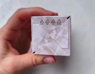 Recycling symbols on the bottom of cosmetic cardboard boxes. These symbols identify the different materials used in the packaging for waste sorting purposes.