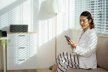 Business women holding smartphone with blank screen, close-up of hands. Space for text.