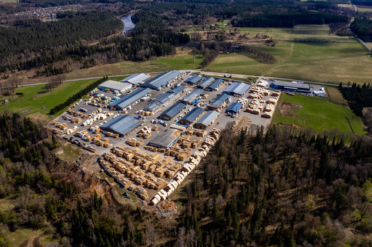 Valmiera, Latvia - May 01, 2021: Aerial view of a lumber mill surrounded by lush forests and open fields showcasing industrial operations and nature