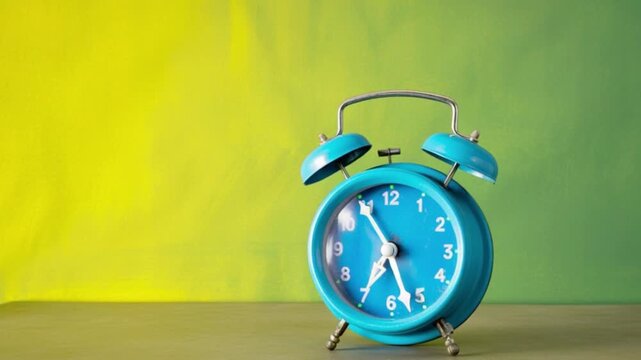 Blue retro alarm clock ticking on colorful yellow and green background symbolizing time management productivity deadlines routines mornings planning urgency lifestyle and modern minimal design