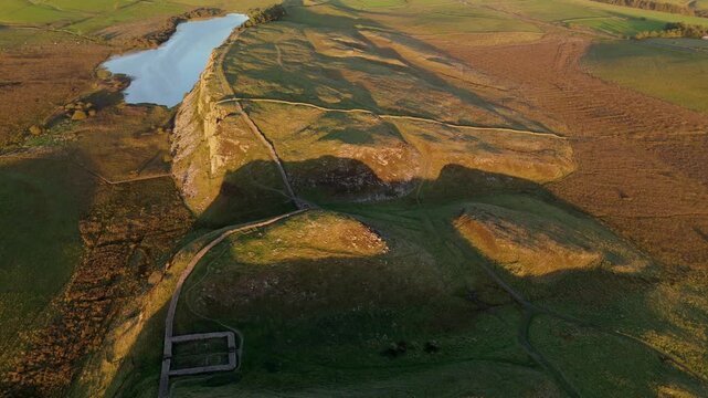 Northumberland UK: 25th Sept 2025: Sycamore Gap (after tree was cut down) at Hadrian's Wall captured by drone during golden hour. Steel Rigg and Crag Lough lake