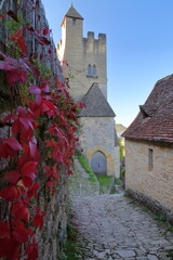 The steep cobbled walkway leading to the castle in Beynac et Cazenac, Dordogne, France, blend into...