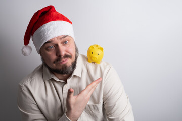 Man in santa hat looking at piggy bank on shoulder