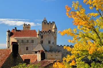 The impressive and well preserved medieval castle of  Beynac et Cazenac, Dordogne, France, viewed from the top of the village, with fortifications, towers and turrets and Autumn colors