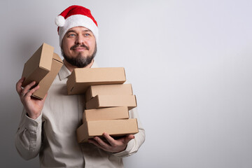 Happy man in santa hat holding stack of delivery boxes