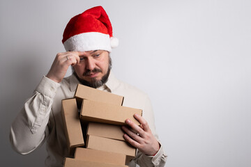 Happy man in santa hat holding stack of delivery boxes