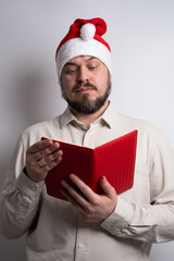 Man in santa hat pointing to red notebook