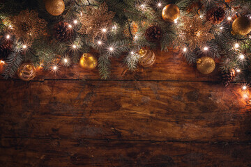 A festive Christmas garland with golden ornaments on a rustic wooden backdrop