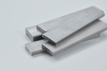High quality close up image of stainless steel metal bars and flat sections with smooth industrial...