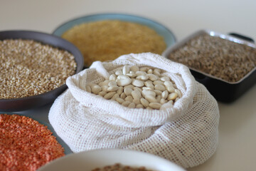 Bowls and bags full of various healthy grains and legumes. Selective focus.
