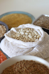 Bowls and bags full of various healthy grains and legumes. Selective focus.