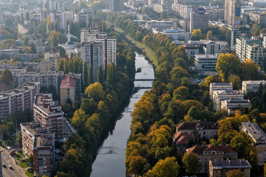 Aerial view of the Miljacka River winding through a cityscape, flanked by trees displaying autumn colors, Sarajevo, Federation of Bosnia and Herzegovina, Bosnia and Herzegovina.
