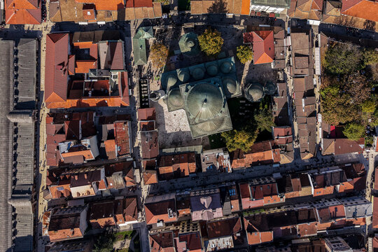 Aerial view of Gazi Husrev-beg Mosque's serene dome amidst the vibrant terracotta rooftops and narrow streets below, Sarajevo, Federation of Bosnia and Herzegovina, Bosnia and Herzegovina.