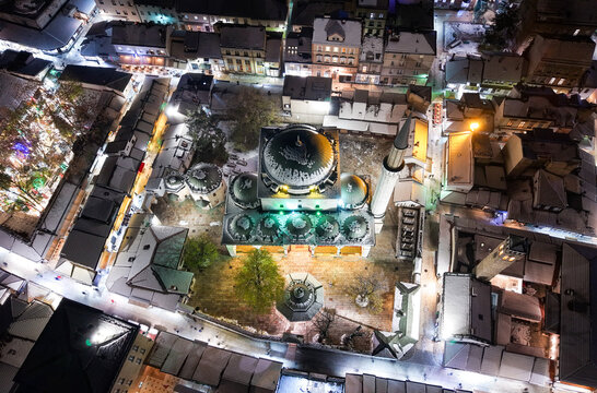 Aerial view of the Gazi Husrev-beg Mosque illuminated against the dark sky, surrounded by snow-covered buildings, Sarajevo, Federation of Bosnia and Herzegovina, Bosnia and Herzegovina.
