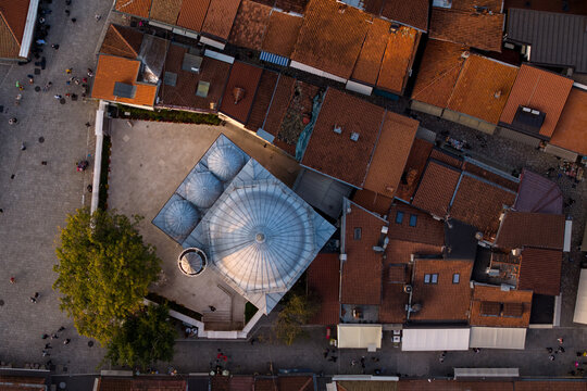 Aerial view of Gazi Husrev-beg Mosque's iconic dome surrounded by a sea of terracotta rooftops and the bustling streets below, Sarajevo, Federation of Bosnia and Herzegovina, Bosnia and Herzegovina.
