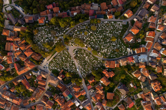 Aerial view of the Kovaci War Memorial Cemetery glows amidst the surrounding red-roofed buildings and verdant trees, Sarajevo, Federation of Bosnia and Herzegovina, Bosnia and Herzegovina.