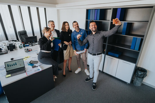 Group of colleagues expressing teamwork and enthusiasm in a modern office environment, embracing collaboration and camaraderie.