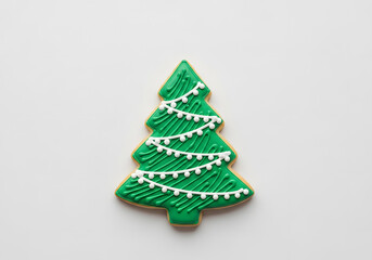 Decorated green christmas tree cookie with white icing garlands on transparent background