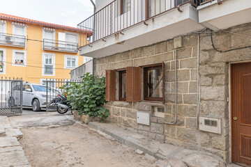 Fototapeta premium Main facade with a gray granite plinth and carved stone cornerstones, displaying the traditional construction elements of farmers' houses.