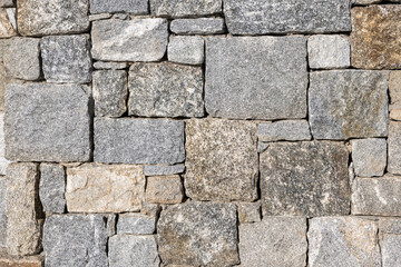 stone brick wall background in earthy tones. close up of stone wall texture. rough texture with a stone pattern. abstract