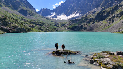 two tourists with backpacks are standing on an island in the mountain lake of the turquoise lake of Kuyguk in Altai