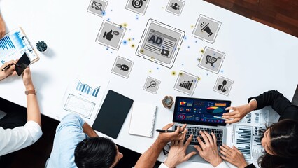 A dynamic workplace scene showcasing a diverse team collaborating on digital marketing strategies. The use of graphs and interactive icons illustrates modern analytical approaches. Raster