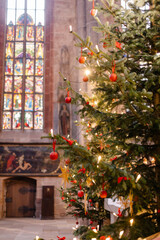 Christmas Tree and Advent Decorations Inside a European Church with Straw Ornaments, Candles, and Warm Holiday Light