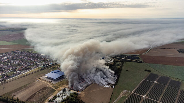 Aerial view of smoke billowing across the landscape, contrasting with the urban and rural divide, a scene of environmental impact, Osijek, Osijek-Baranja County, Croatia.