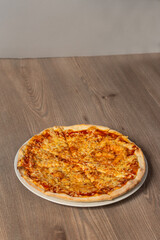 Sliced Pizza with Mozzarella cheese, Tomatoes and Spices. Italian pizza. Pizza Margherita or Margarita on wooden background