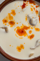 Traditional Bosnian dumplings — klepe. The dish served with a yoghurt sauce and spices on a wooden table