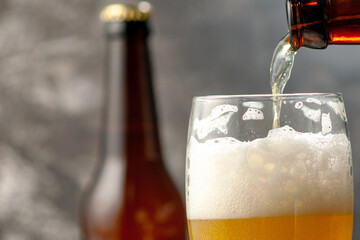 Pouring Cold Craft Beer into a Glass with Foamy Head from a Dark Bottle