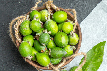 Wooden Bowl Filled with Fresh Green Feijoa Fruits and Rope Handle Detail