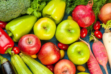 Assortment of vibrant fruits and vegetables including apples, pomegranate, and broccoli