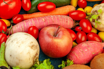 Assortment of vibrant root vegetables, apples, sweet potato, and kiwi fruit