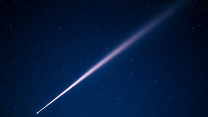 A brilliant meteor streak with a glowing tail in a star-filled night sky.