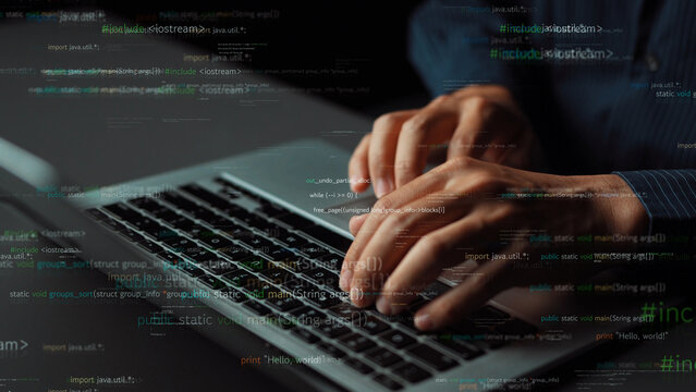 A dynamic close-up view of hands typing on a laptop keyboard. The coding overlay adds depth, symbolizing the fusion of technology and everyday life in a modern workspace. Xenic