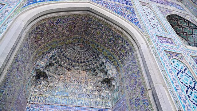 Close-up view of the facade and intricate tile decoration of the Tilya Kori Madrasa in Samarkand, Uzbekistan.